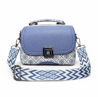 Blue handbag with a patterned strap on a white background