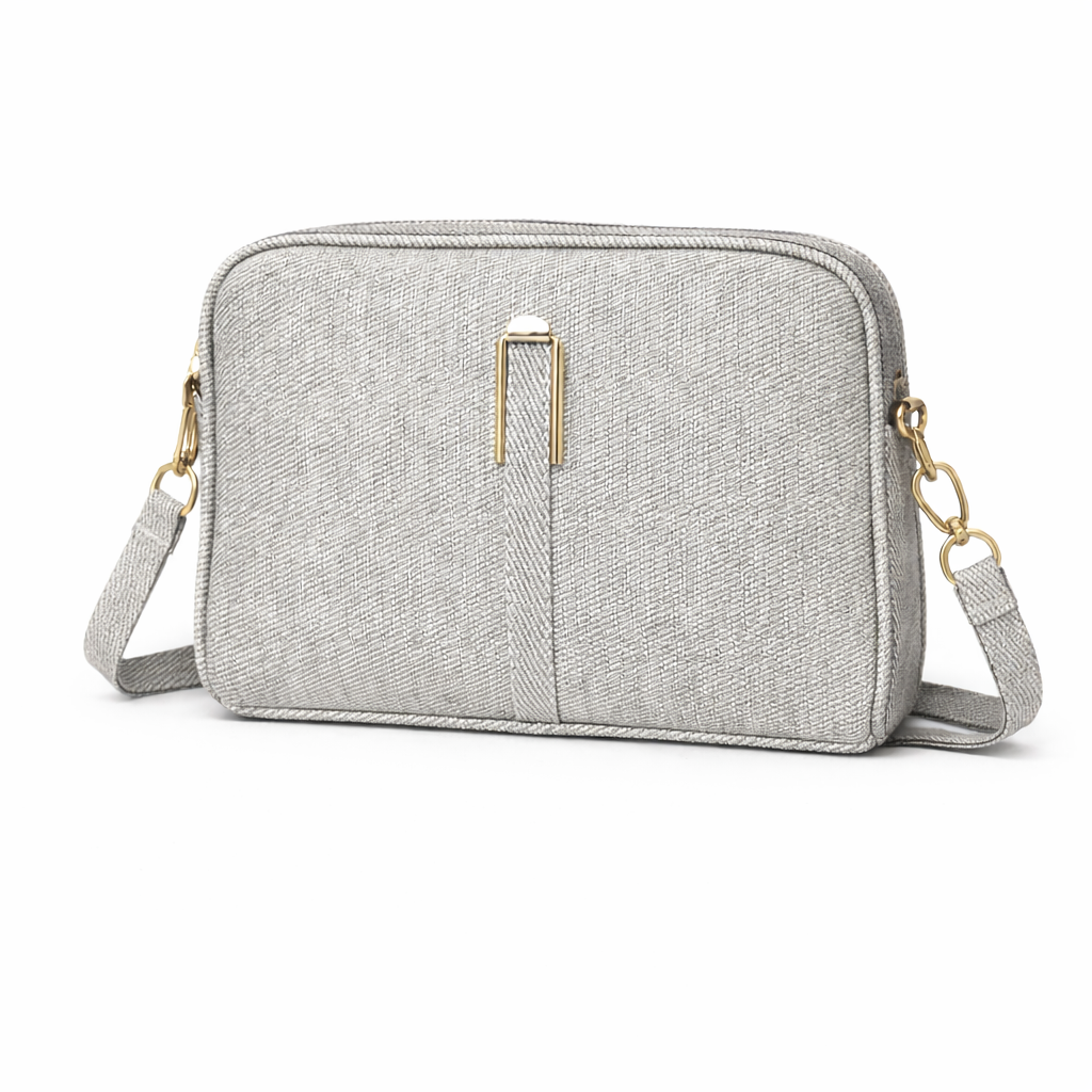 Gray crossbody bag with gold accents on a white background