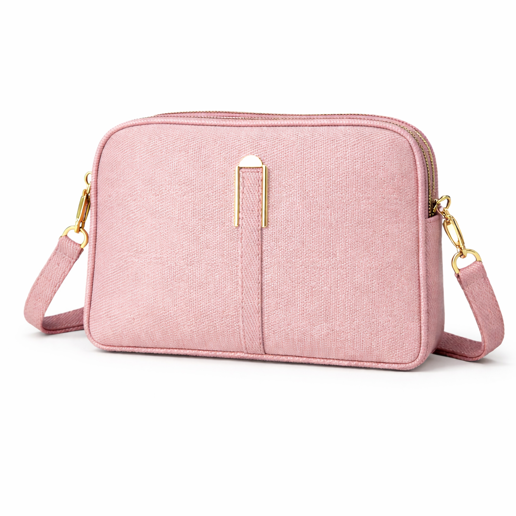 Pink crossbody bag with gold accents on a white background